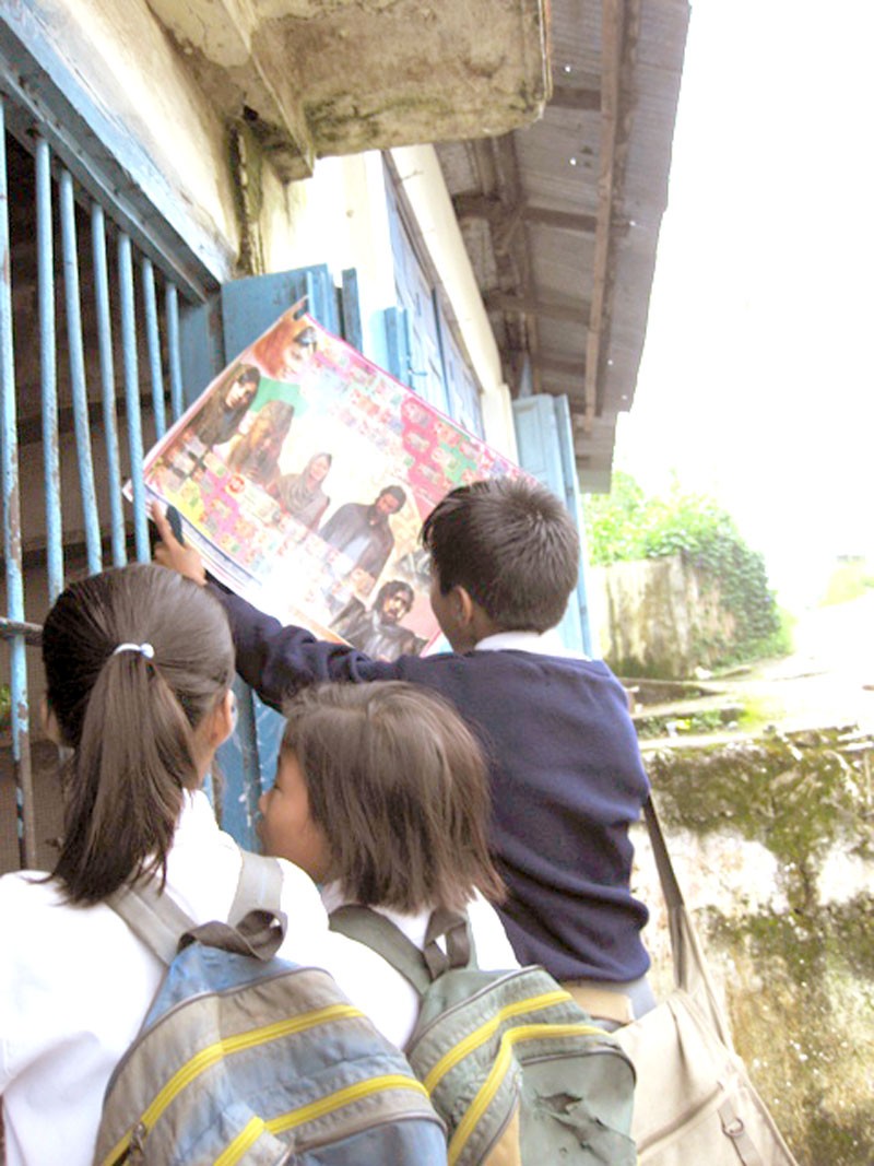 STICKY SITUATION: School children in Mokokchung try their fortunes from a poster on which are numbers that  they hope to match with those in stickers  bought from the shop.