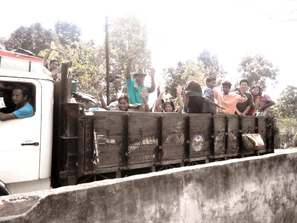 Displaced persons from the Silonijan Relief Camp, Bokajan sub division, wave on March 20, 2014, as they head back home for the first time since December 2013.
