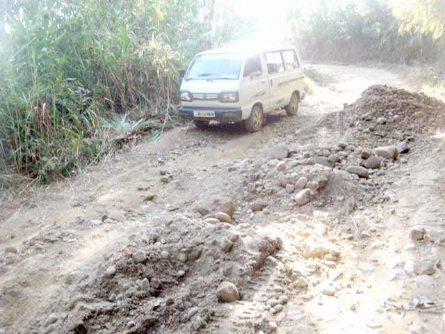 A vehicle trying to maneuver a pothole while coming down from Molungkimong village on November 11. (Morung Photo)