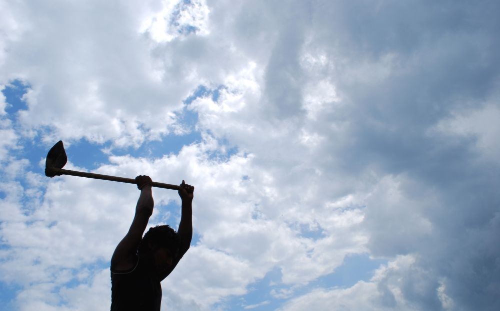 A farmer is silhouetted against monsoon clouds as he ploughs his field in Dimapur. (Caisii Mao File Photo)