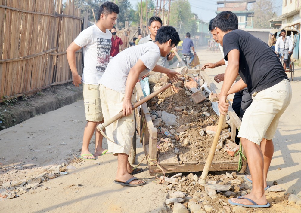 Youth volunteers filling up potholes near Signal Bosti evening bazaar on April 12. (Photo Courtesy/Aden Jamir)
