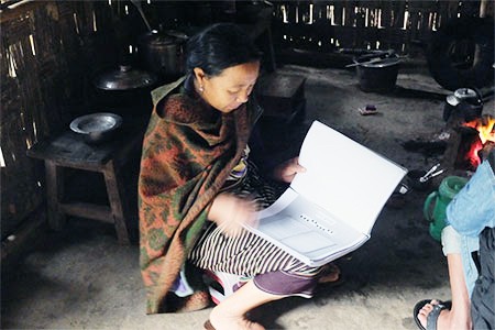 A disciple of Gaidinliu, looking at the notebooks in Laisong village, Assam, in 2014. ( Photo Credit: Arkotong)