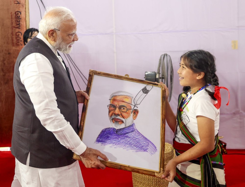 Churachandpur: Prime Minister Narendra Modi being felicitated by a girl with his painting at relief camp in Churachandpur, Manipur, on Saturday, September 13, 2025. (Photo: IANS/PMO)
