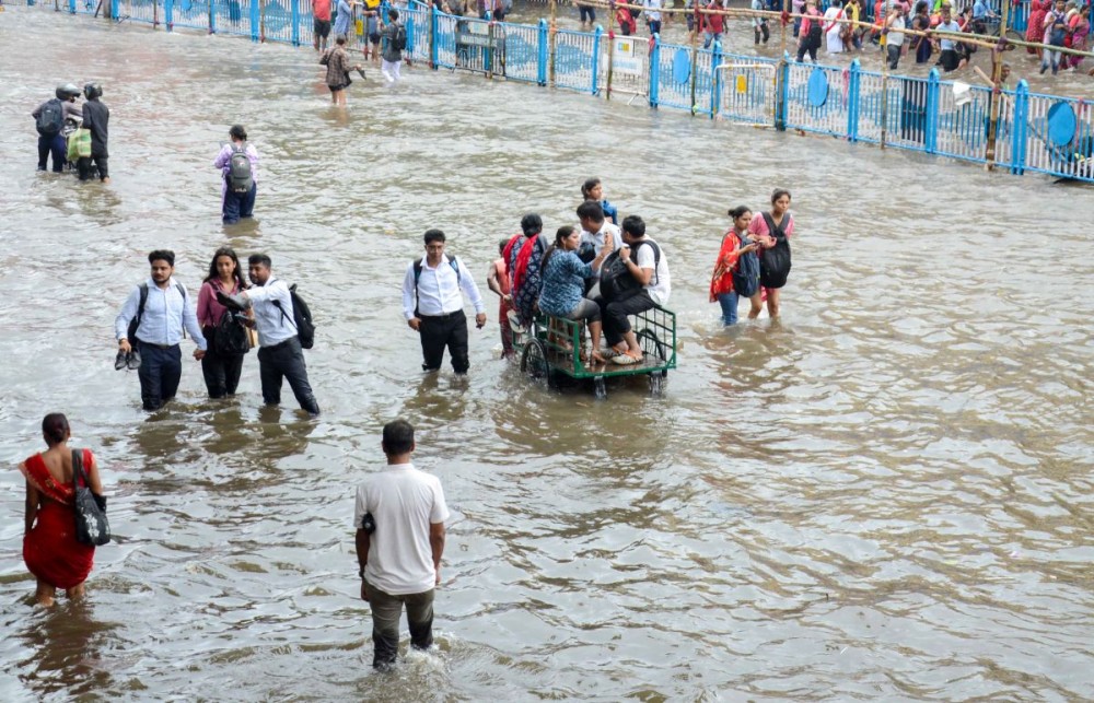 Kolkata: Commuters pass on a waterlogged road after heavy rainfall in Kolkata, West Bengal on Tuesday, September 23, 2025. (Photo: IANS)