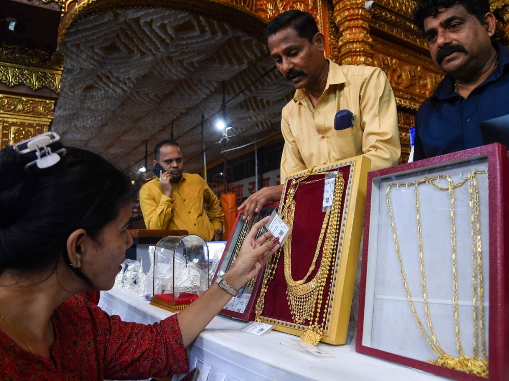 Mumbai: A woman looks at a gold jewellery piece during an open auction of gold and silver items offered by devotees at the feet of Lalbaugcha Raja during the Ganesh festival in Mumbai on Thursday, September 11, 2025. (Photo: IANS)
