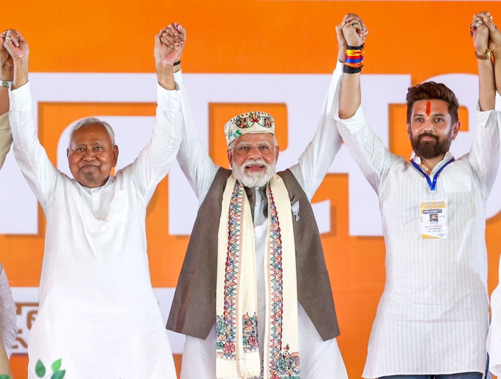 Samastipur: Prime Minister Narendra Modi joins hands with Bihar Chief Minister Nitish Kumar and Union Minister and Lok Janshakti Party (Ram Vilas) President Chirag Paswan during a public rally for the 2025 Bihar Assembly elections in Samastipur, Bihar, on Friday, October 24, 2025. (Photo: IANS/PMO)