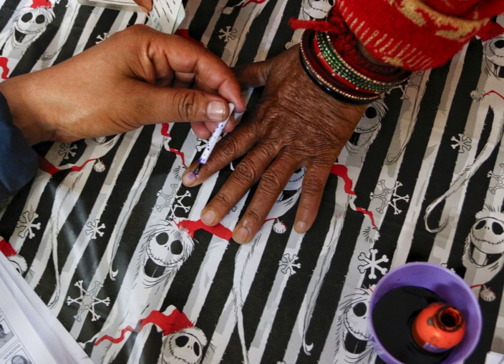 An election official applies indelible ink on a voter's finger during polling for the Delhi Assembly election at Sant Nagar in New Delhi on February 5, 2025. (IANS File Photo)