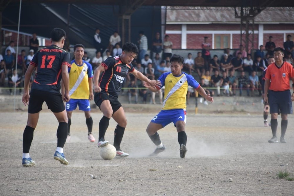 Players of Doyang Strikers Mokokchung (in black with red stripes) and Thunderbolt FC (in yellow/blue) in action during their Day 4 match of the 27th MDFA Trophy 2025 at Imkongmeren Sports Complex, Mokokchung, on October 17.