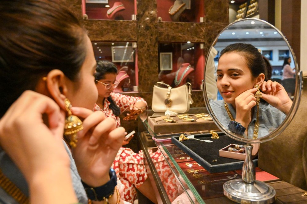 Jabalpur: A woman tries on jewellery ahead of the Dhanteras and Diwali festival at a jewellery shop in Jabalpur on Friday, October 17, 2025. (Photo: IANS)