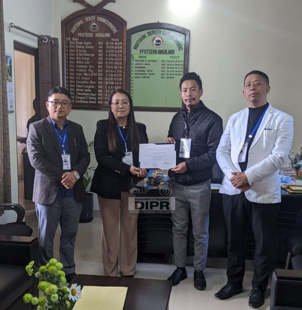 ADC, Pfutsero, Mhalo Humtsoe handing over the winning certificate of Pfutsero Town Council, Ward 11 Zipa to Krokulo Khutso.  (DIPR Photo)