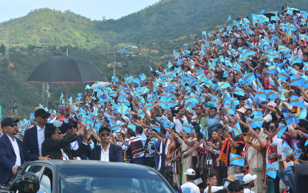 NSCN (IM) General Secretary Th Muivah greets people waving Naga flags and cheering as he arrives for a civic reception at Senapati, Manipur, after visiting his birth village Somdal on October 29. (Morung Photo)
