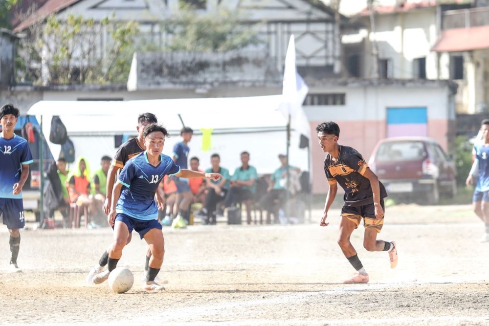 Chargers FC (in black and gold) and Sangpang Riju (in blue) in action during their league match on Day 3 of the 27th MDFA Trophy 2025 at Imkongmeren Sports Complex, Mokokchung, on October 16.