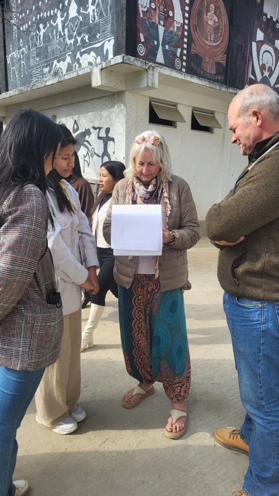 Researchers from Kohima Science College (Autonomous) interact with foreign tourists during an impact assessment survey of the Hornbill Festival at Naga Heritage Village, Kisama. (Morung Photo)