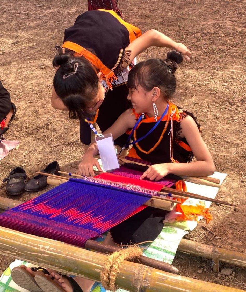 Nine-year-old Nürülu Rhakho and 11-year-old Veritolu Lohe share a quick laugh during a live demonstration of loinloom weaving at the 11th Naga Loinloom Festival at Weaver’s Place, Diezephe Village, on December 8. (Morung Photo)