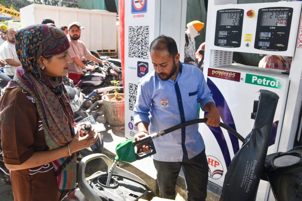 Amritsar: A petrol station attendant refuels a scooter ridden by a woman commuter amid long queues at a fuel station in Amritsar on Friday, March 27, 2026. (Photo: IANS)