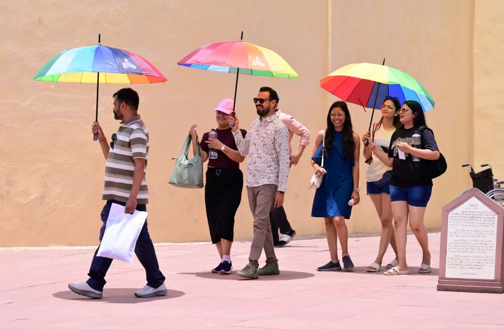 Tourists shield themselves with colorful umbrellas from the scorching heat as the temperature touches 43 degrees Celsius during a hot summer day, at Jantar Mantar in Jaipur on May 26, 2026. (IANS Photo)