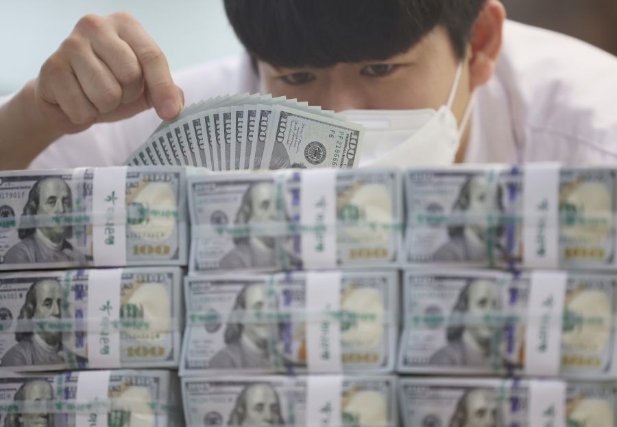 A clerk sorts US$100 banknotes at the headquarters of Hana Bank in Seou. (IANS File Photo)
