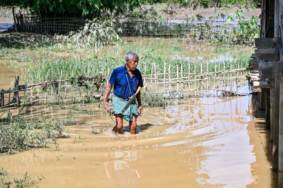 A man wades through floodwaters in the flood-affected Jonai Revenue Circle of Dhemaji district, Assam, on June 30, 2026. (IANS Photo)