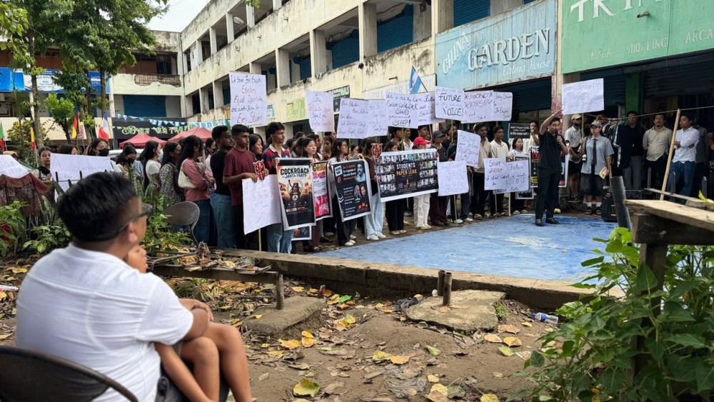 A FRONT-ROW LESSON IN DEMOCRACY: A father and daughter watch as the peaceful protest themed “Nagaland Supports CJP: We Stand With Sonam Wangchuk” unfolds at Supermarket, Dimapur, on July 20; perhaps a front-row lesson in democracy for the young child and others gathered. Her father later spoke about securing the future of the younger generation, demanding accountability in education, and the vital importance of raising a civil, democratic voice, the very concerns that drove him to join the movement. (Morung Photo)