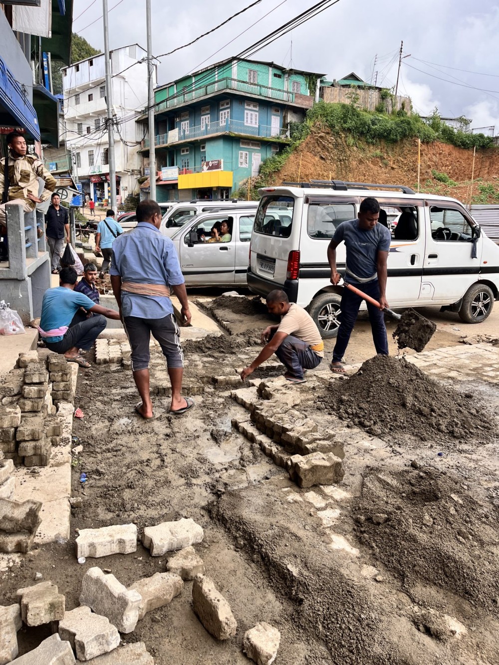 Workers lay paver blocks at the Police Point parking area in Wokha on July 14.  The  Wokha Town Council is developing a public parking facility to improve parking and traffic flow. (Morung Photo)