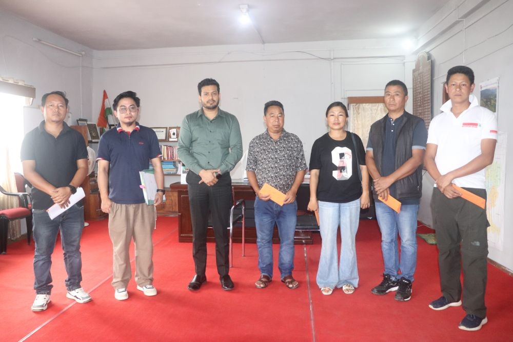 Deputy Commissioner and DDMA Chairman Dharam Raj hands over emergency relief assistance to families affected by recent landslides in Zunheboto town at the Deputy Commissioner’s Chamber on July 22. (Morung Photo)