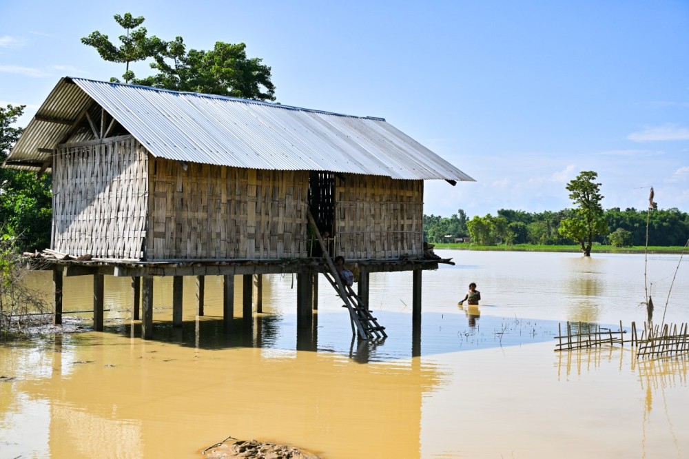 Dhemaji: Children sit at a partially inundated house in the flood-affected Jonai Revenue Circle of Dhemaji district, Assam, on Tuesday, June 30, 2026. (Photo: IANS)