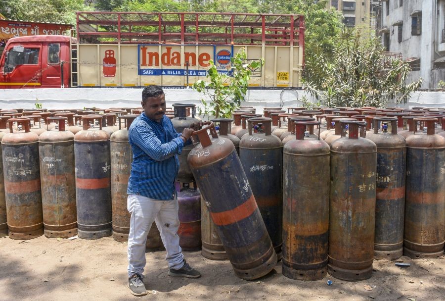 A gas agency worker holds an LPG cylinder following a hike in commercial LPG prices in Surat, Gujarat on May 02, 2026. (IANS File Photo)