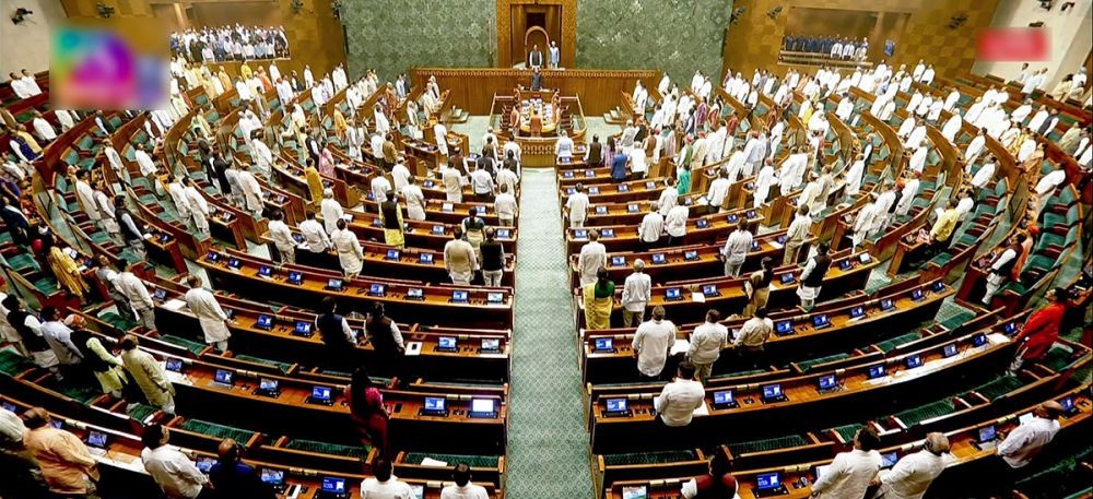 Lok Sabha Speaker Om Birla and other MPs stand for the national song in the House during the Monsoon Session of Parliament in New Delhi on August 13, 2026. Lok Sabha on Thursday adjourned sine die. (IANS/Sansad TV Photo)