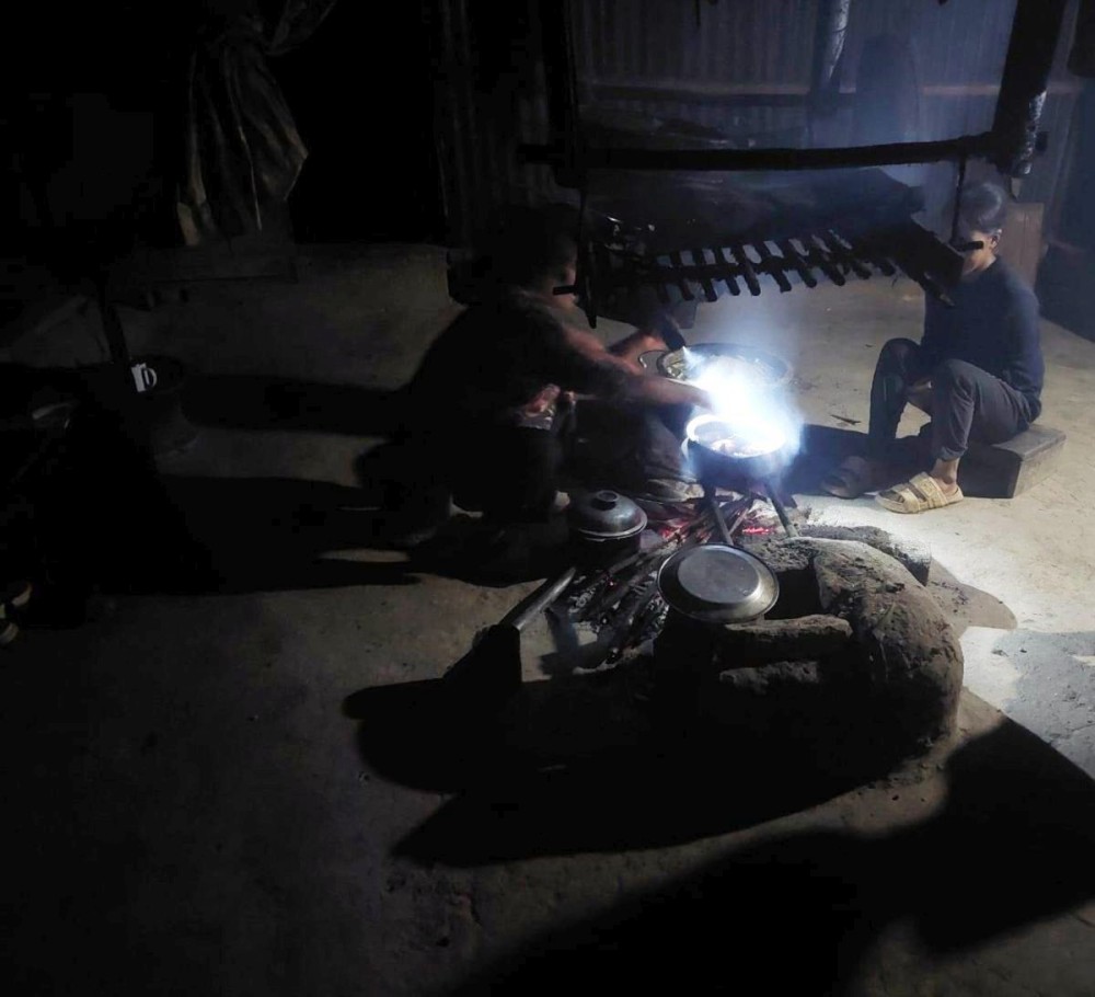 A family in Hanyuk village uses a torch for light in their kitchen as the village remains without electricity for over a month following repeated transformer damage. (Morung Photo)