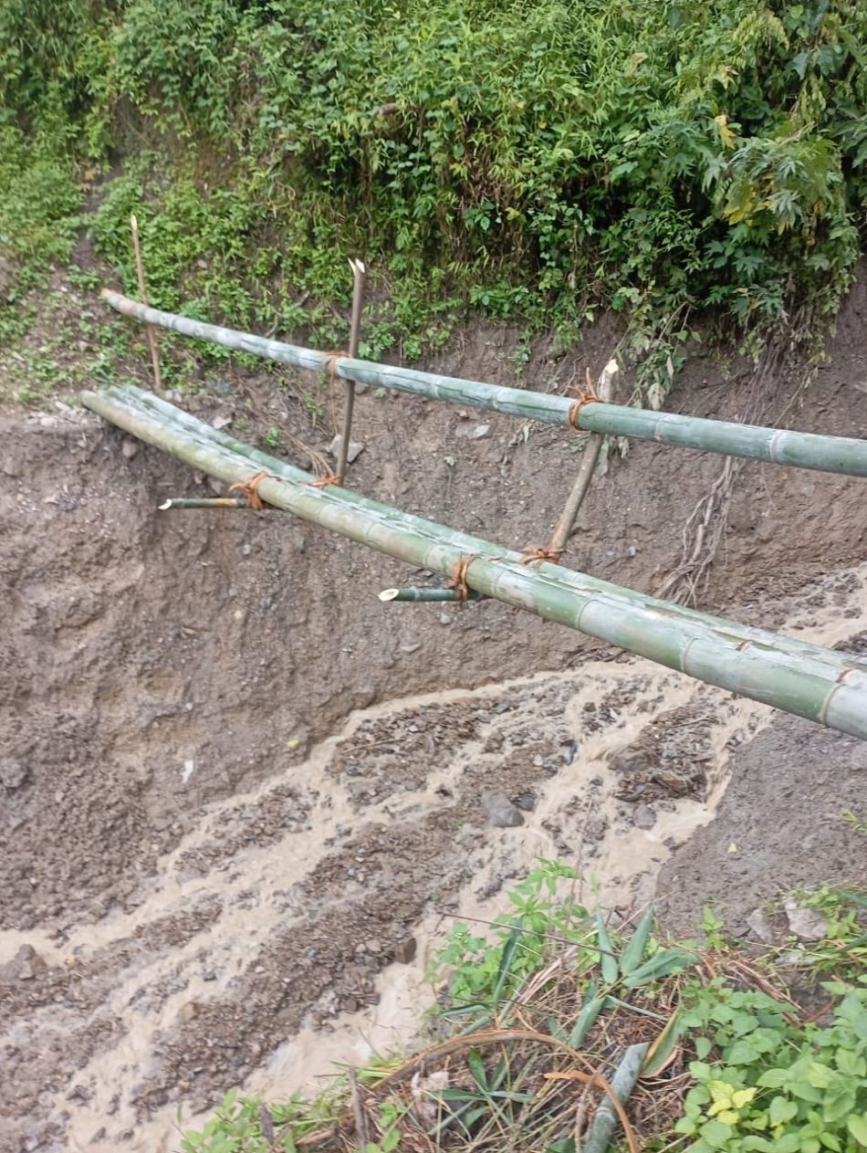 The second temporary bamboo bridge over a deep, rain-eroded channel leading to the jhum fields of Chisholimi. The first makeshift bridge was washed away by rainfall, prompting villagers to construct another one on September 7.