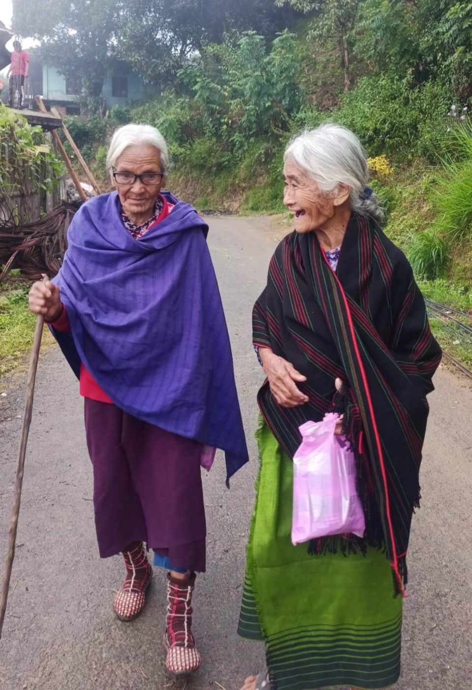 Two elderly women return home with gift tokens they received during the International Day of Older Persons celebration, held October 1 at White Hall, Noklak village. (Morung Photo)