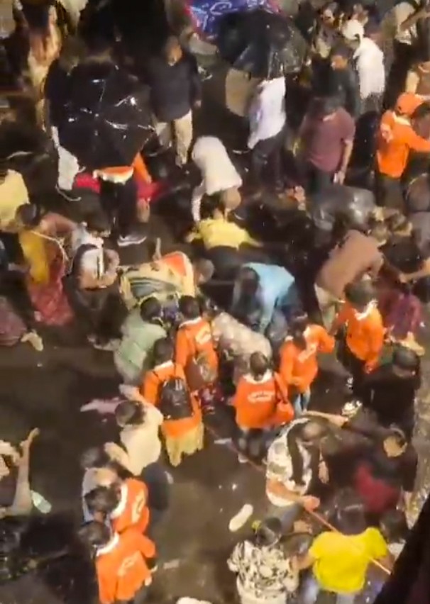 People help the injured after a stampede-like situation occurred at the Chorbagan Sarbojanin Durga Puja pandal in Kolkata, West Bengal, on Saturday, October 17, 2026. (Photo: IANS/Video Grab)